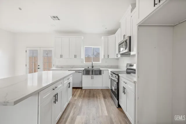 a kitchen with granite countertop a sink stove and cabinets