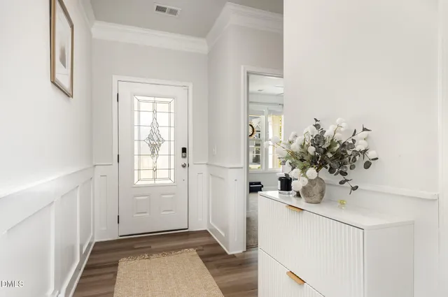 a front view of a house with a yard and potted plants