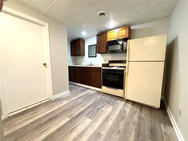 a view of kitchen with stainless steel appliances granite countertop a refrigerator and a stove top oven