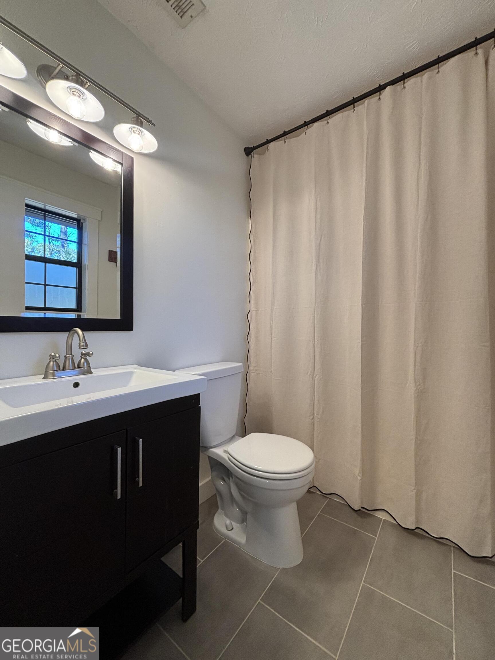 14 Emory Street Newnan, GA 30265 - Photo 19 of 27 a bathroom with a toilet sink and mirror
