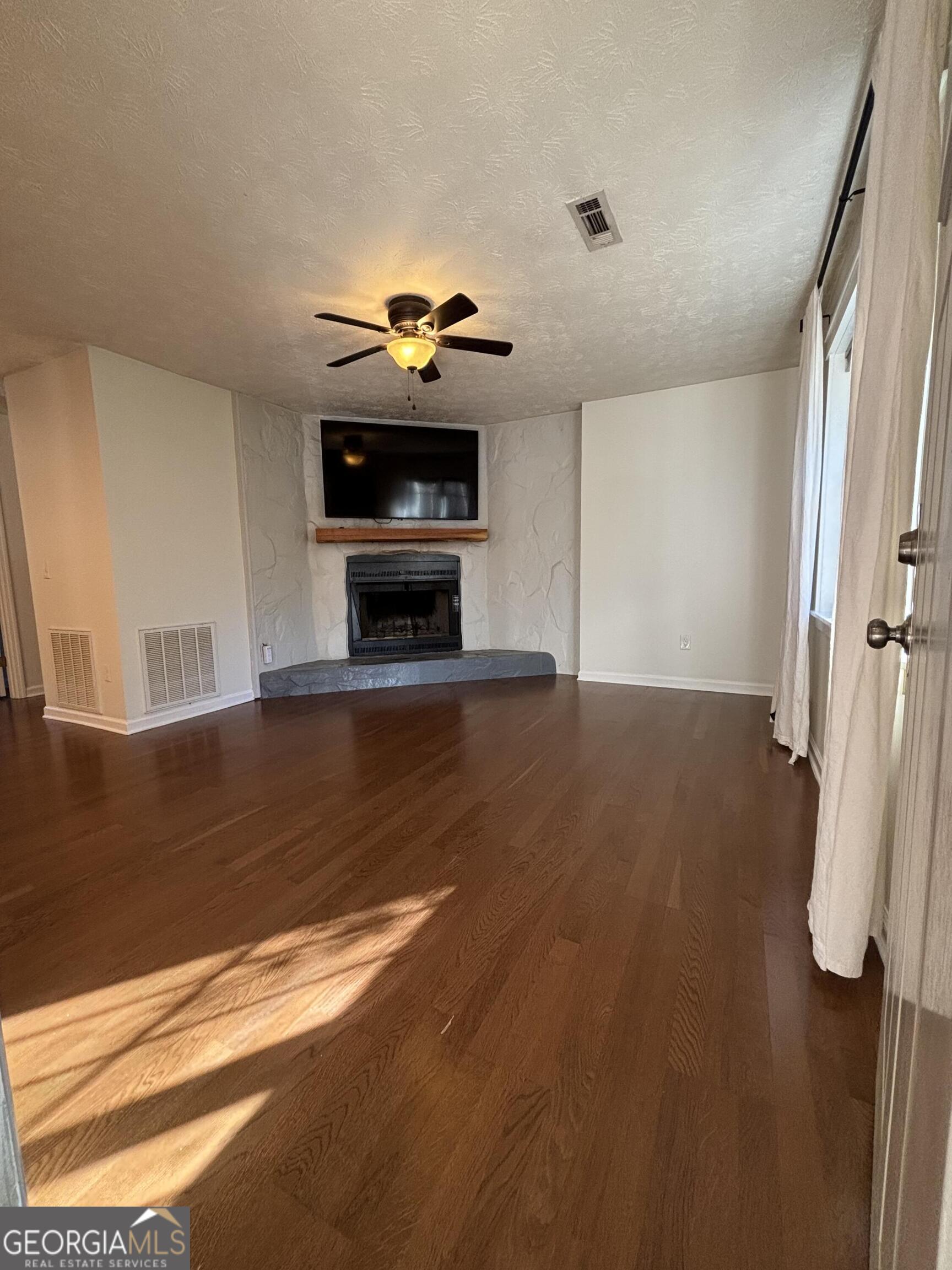 14 Emory Street Newnan, GA 30265 - Photo 3 of 27 a view of a livingroom with wooden floor and a fireplace