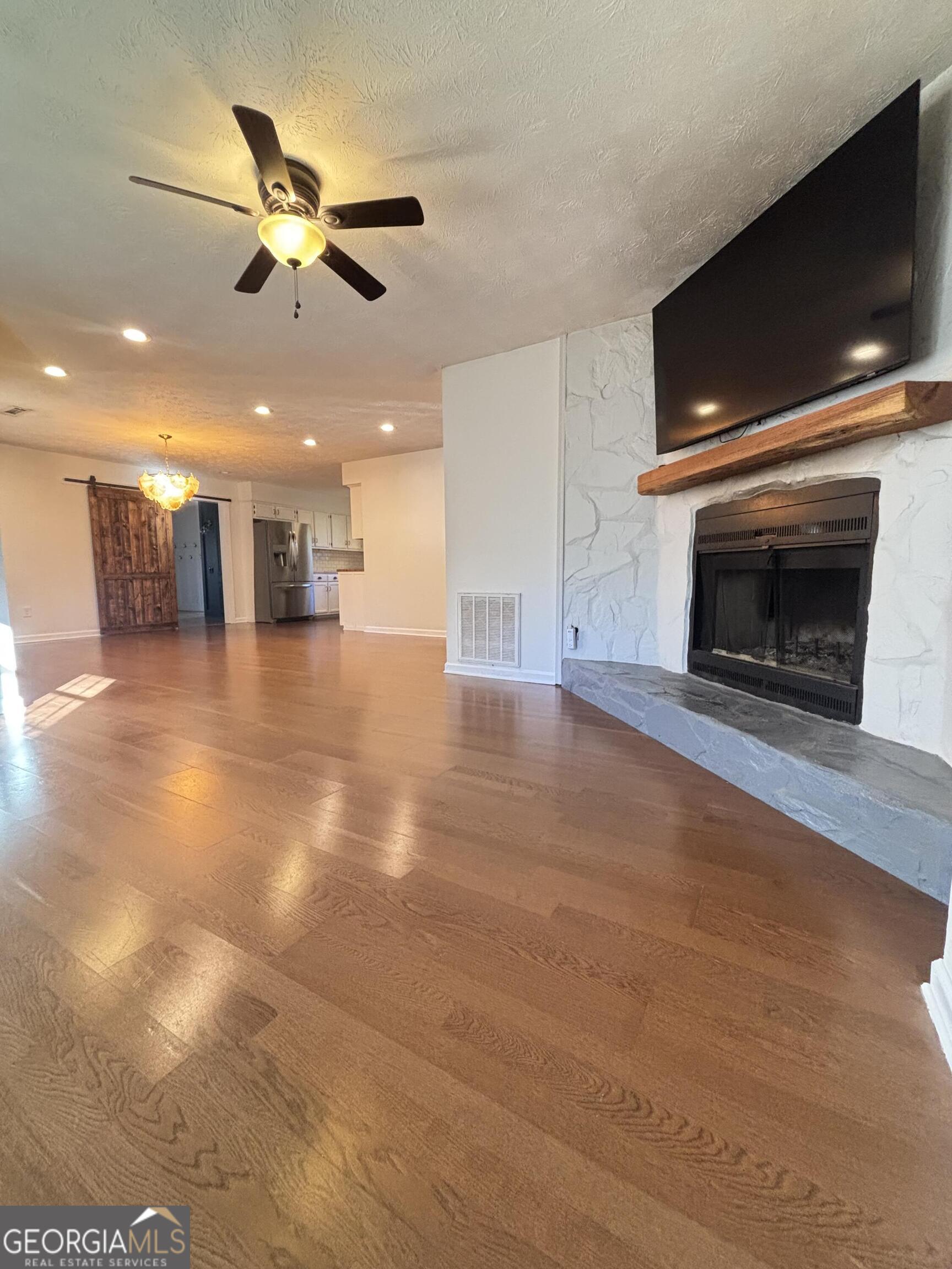 14 Emory Street Newnan, GA 30265 - Photo 4 of 27 a view of a livingroom with a fireplace a ceiling fan and wooden floor