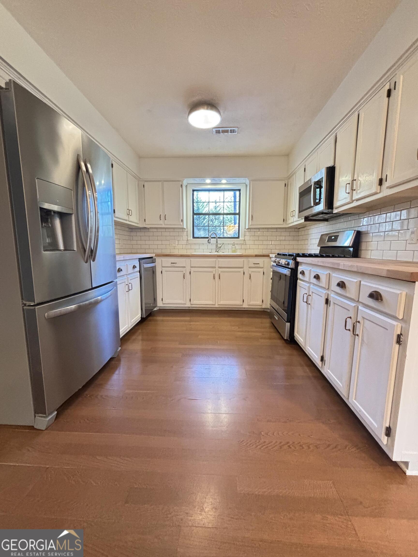 14 Emory Street Newnan, GA 30265 - Photo 7 of 27 a kitchen with granite countertop white cabinets and stainless steel appliances