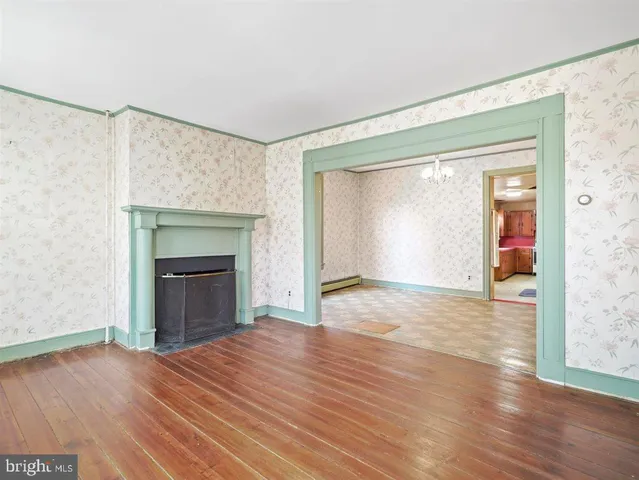 a view of empty room with wooden floor and fireplace