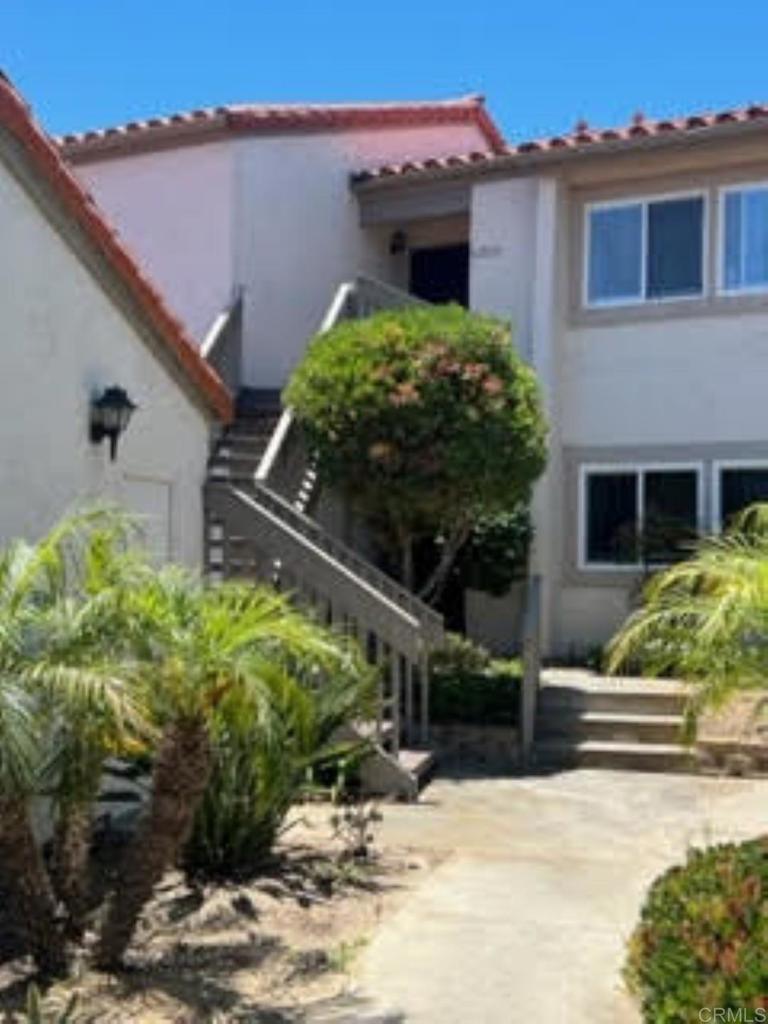 6701 Paseo Del Norte, Unit E Carlsbad, CA 92011 - Photo 17 of 23 a front view of a house with a yard