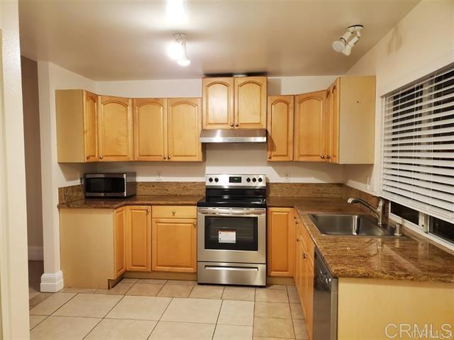 6701 Paseo Del Norte, Unit E Carlsbad, CA 92011 - Photo 2 of 23 a kitchen with stainless steel appliances granite countertop a stove a sink and a microwave