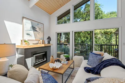 a living room with furniture fireplace and a large window