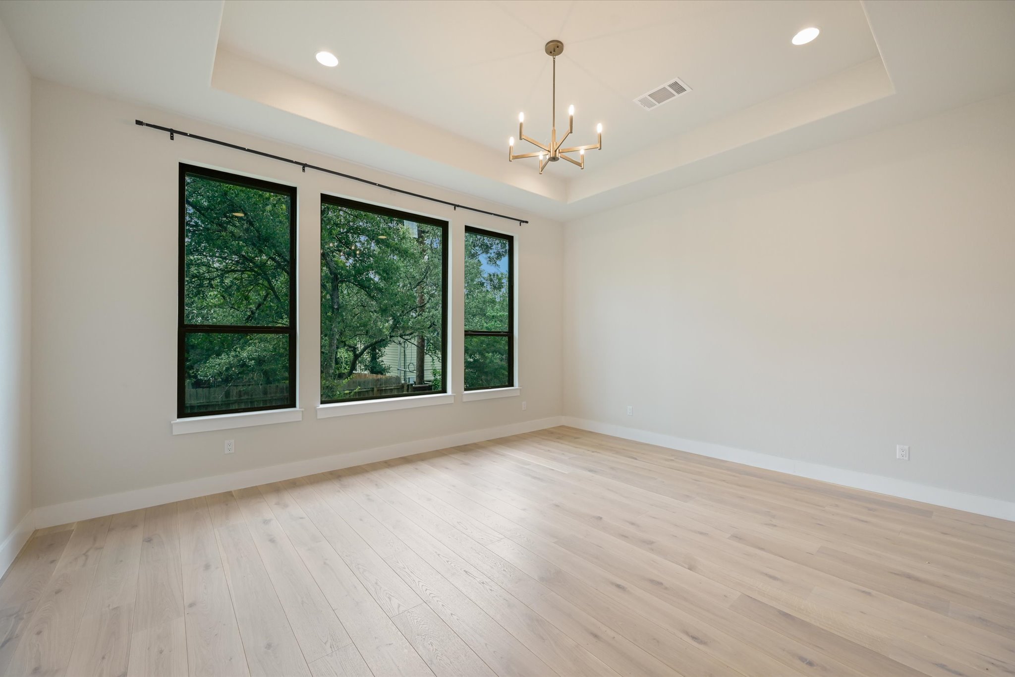 913 Presa Arriba Road Austin, TX 78733 - Photo 16 of 30 Bright windows frame lush greenery in this inviting, spacious living area.