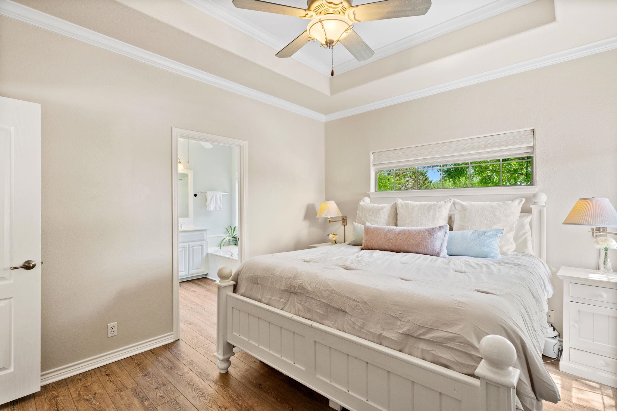 2409 Mormon Mill Road Marble Falls, TX 78654 - Photo 16 of 30 a bedroom with a bed and a chandelier