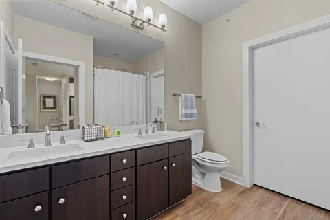 a bathroom with a double vanity sink toilet and a mirror