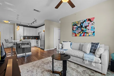 a living room with furniture and a dining table with kitchen view