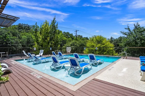 a view of a chairs and table on the wooden roof deck