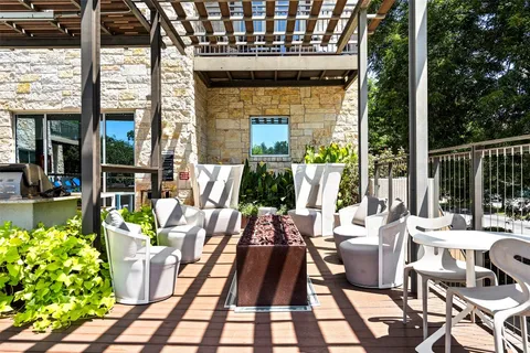 a view of a patio with table and chairs potted plants and large tree