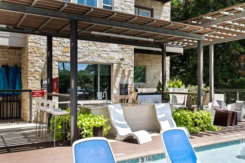 a view of a patio with couches chairs potted plants and floor to ceiling window