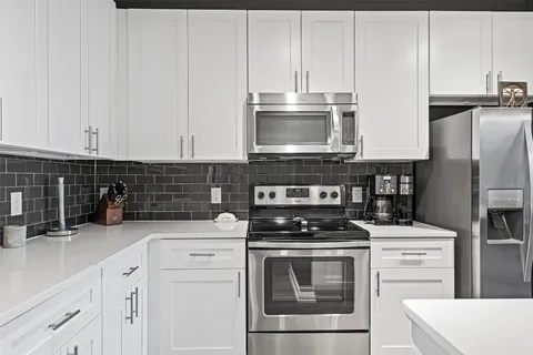 a kitchen with cabinets stainless steel appliances and a counter space