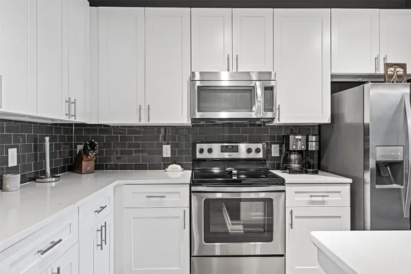 a kitchen with cabinets stainless steel appliances and a counter space