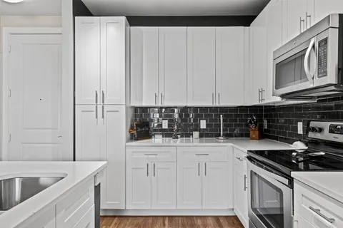 a kitchen with stainless steel appliances granite countertop a sink stove and cabinets