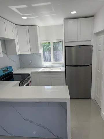 a kitchen with a refrigerator and a sink