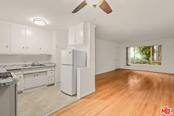 a kitchen with granite countertop a stove a sink and a refrigerator