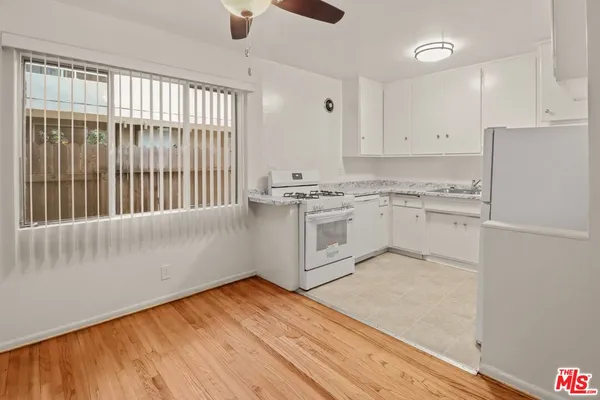 a kitchen with stainless steel appliances granite countertop a stove a sink and white cabinets