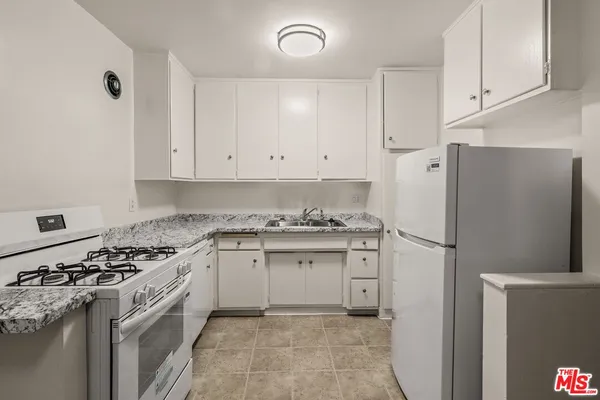 a kitchen with a stove a sink and a refrigerator