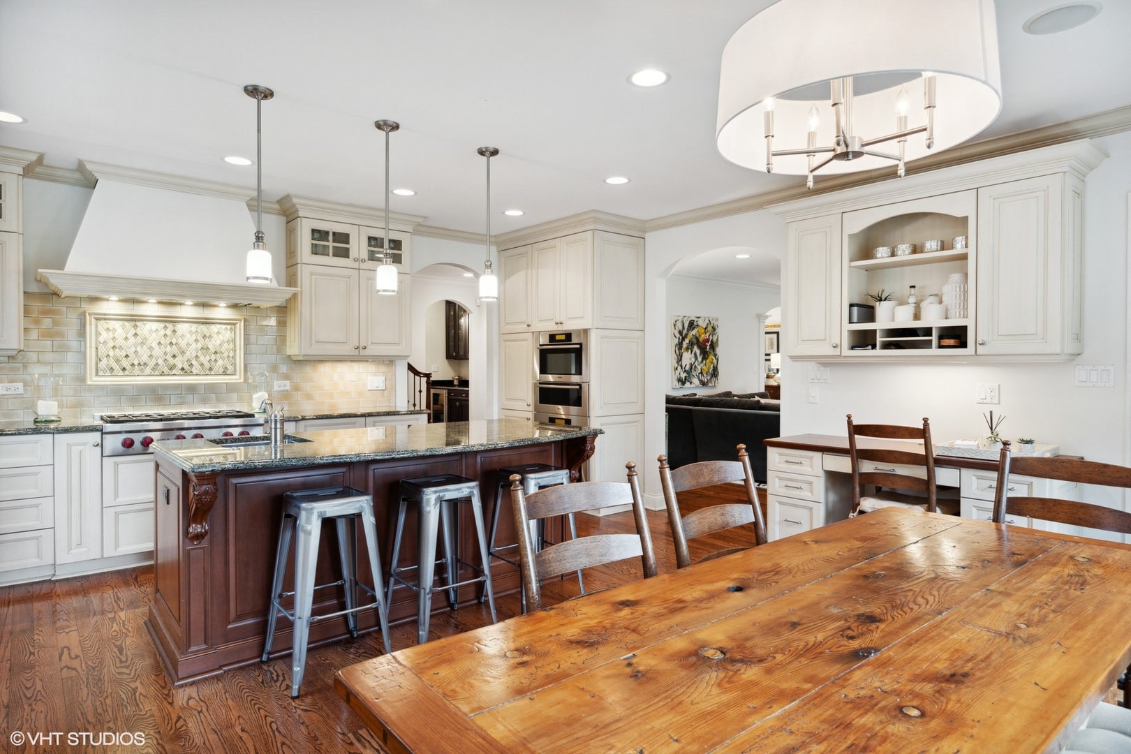1111 Seneca Road Wilmette, IL 60091 - Photo 9 of 50 a kitchen with stainless steel appliances kitchen island granite countertop a table chairs in it and wooden floors