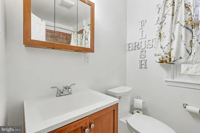 a bathroom with a sink a toilet and mirror