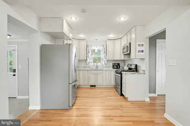 a kitchen with white cabinets and stainless steel appliances
