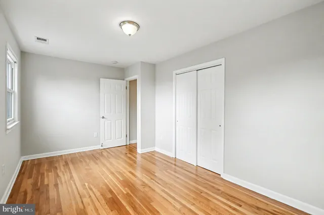 a view of a room with wooden floor and white walls