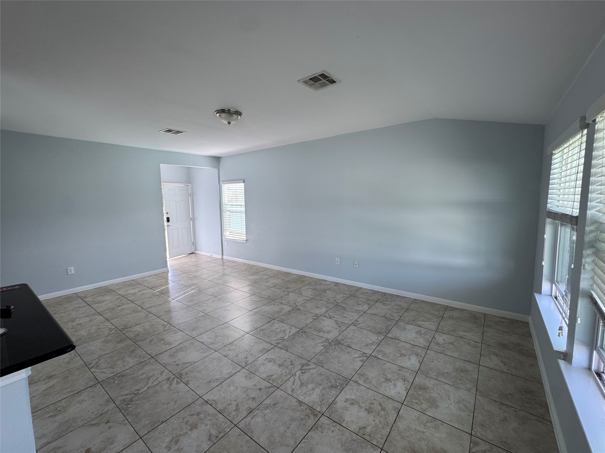 1520 Portchester Castle Path Pflugerville, TX 78660 - Photo 4 of 26 Porcelain tile floors span this inviting living area, leading to an entryway with natural light.