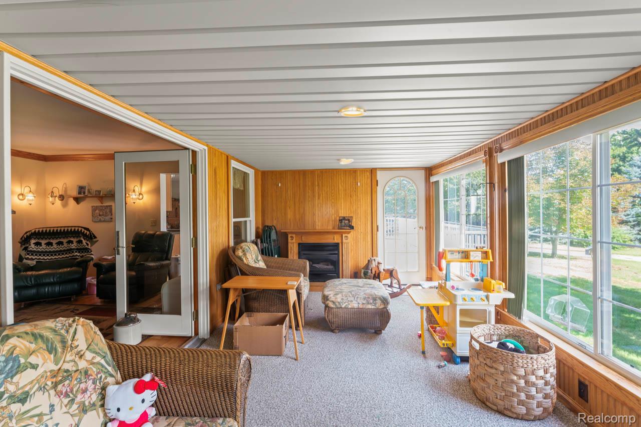 1591 Baldwin Road Lapeer, MI 48446 - Photo 6 of 46 Sunroom with wood walls, carpet floors, and ornamental molding