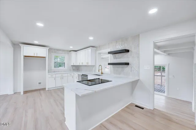 a kitchen with granite countertop white cabinets and white appliances
