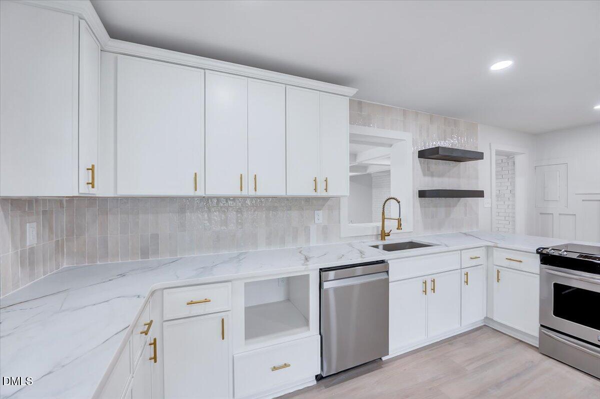 601 West Walnut Street Selma, NC 27576 - Photo 10 of 30 a kitchen with white cabinets stainless steel appliances and sink
