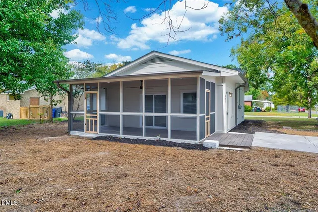 a view of a house with a yard and large tree
