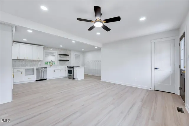 an empty room with windows and fireplace