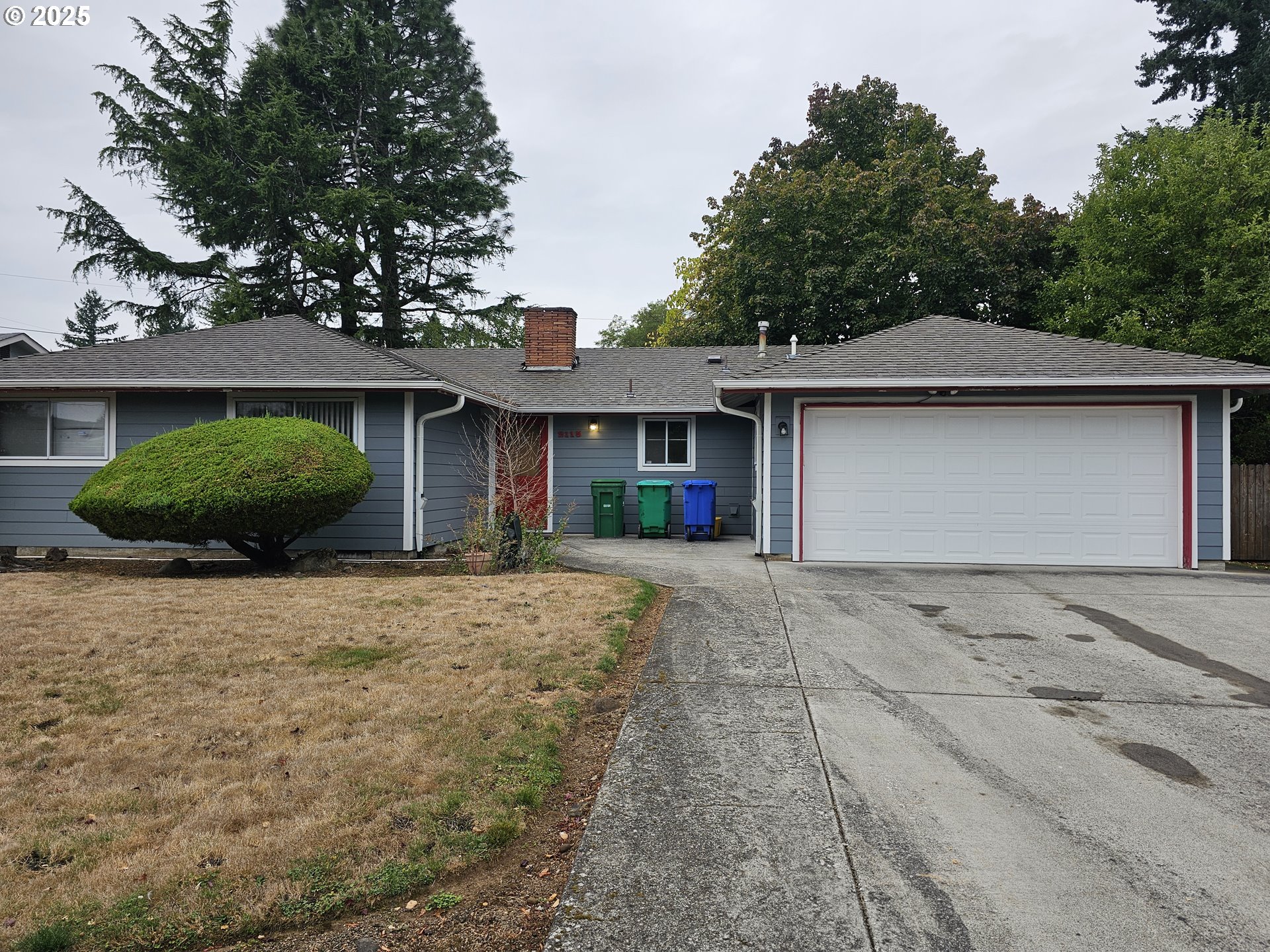 a front view of a house with a garden and garage