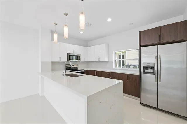 a kitchen with stainless steel appliances a refrigerator and a sink