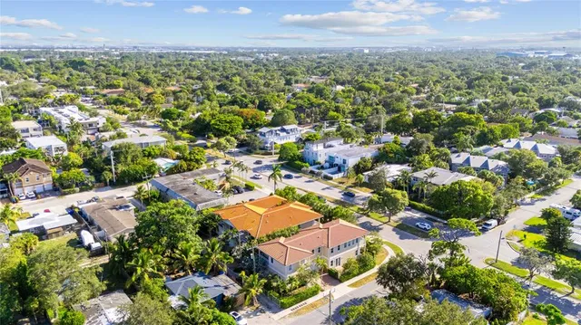 an aerial view of residential houses with outdoor space and trees