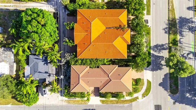 an aerial view of a house with a yard and large trees