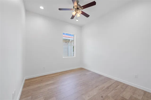 an empty room with a window and ceiling fan