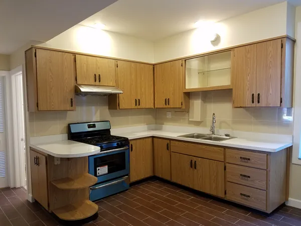 a kitchen with sink a stove and cabinets