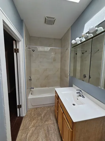 a bathroom with a tub sink and mirror