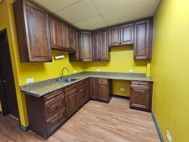 a kitchen with stainless steel appliances granite countertop wooden cabinets a stove top oven a sink and dishwasher