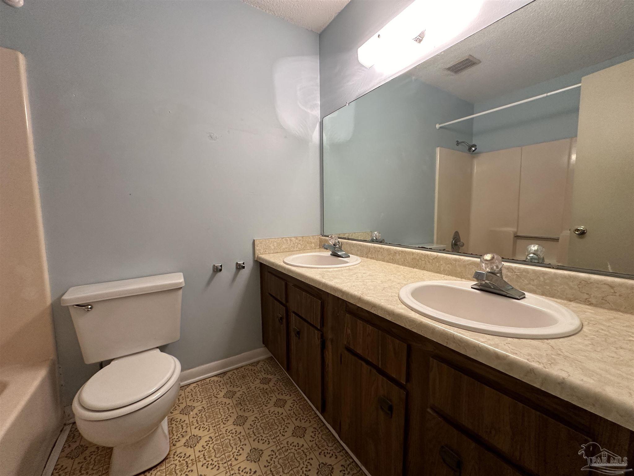 511 Maple Avenue Niceville, FL 32578 - Photo 11 of 17 a bathroom with a granite countertop sink toilet and mirror