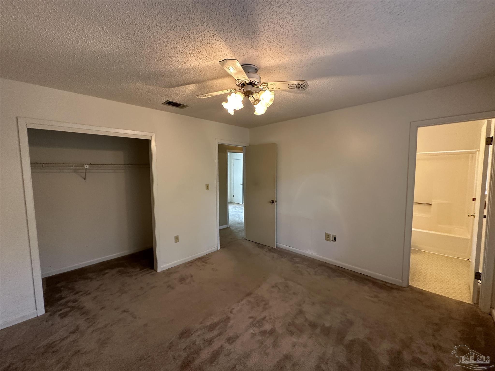 511 Maple Avenue Niceville, FL 32578 - Photo 15 of 17 an empty room with closet and a chandelier fan
