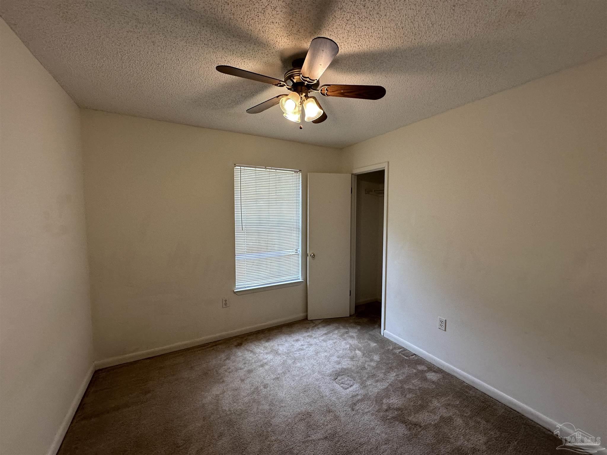 511 Maple Avenue Niceville, FL 32578 - Photo 9 of 17 an empty room with a ceiling fan and a window