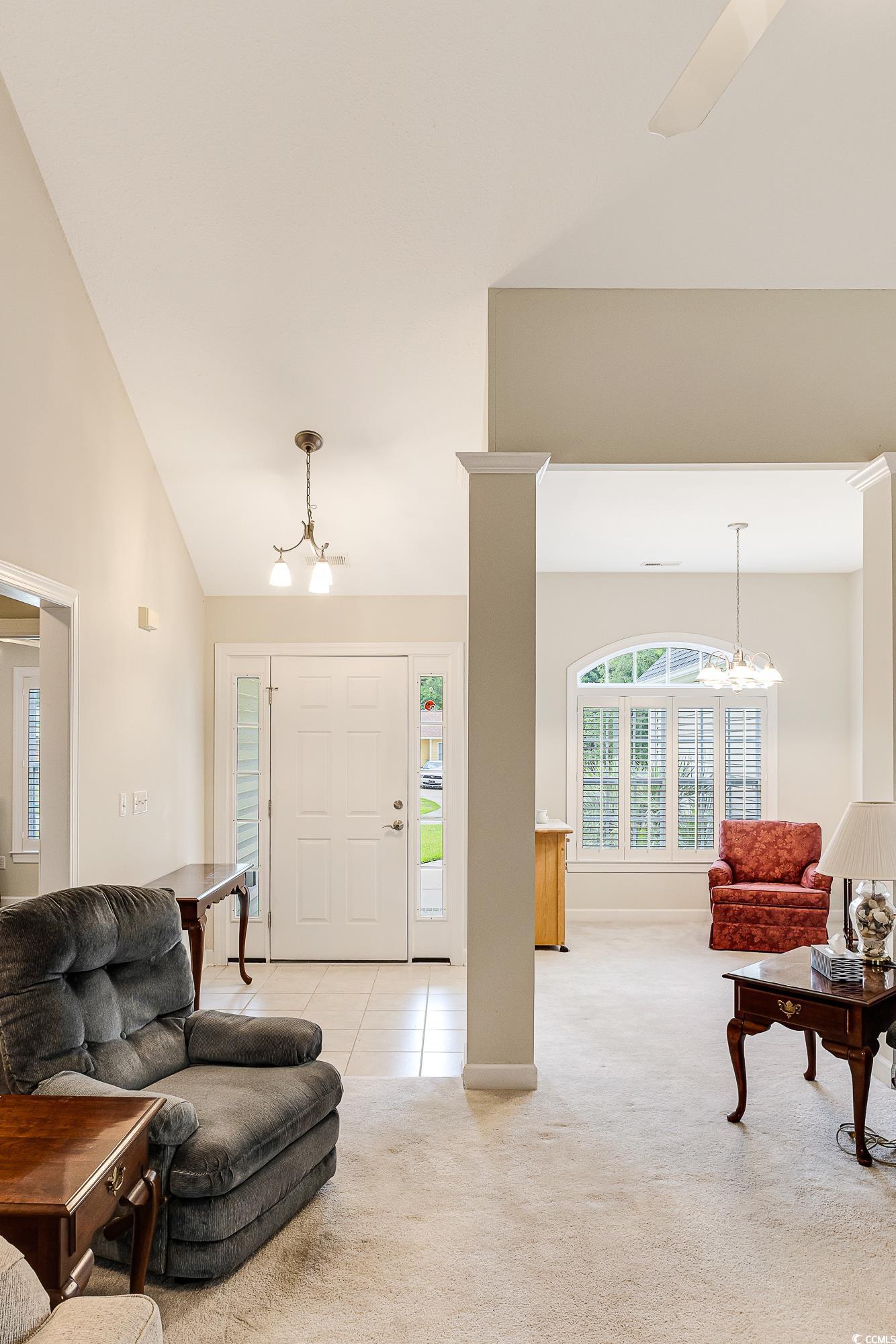 101 Cedar Tree Lane Southwest Calabash, NC 28467 - Photo 11 of 40 Living area featuring a chandelier, light carpet, high vaulted ceiling, and light tile patterned floors