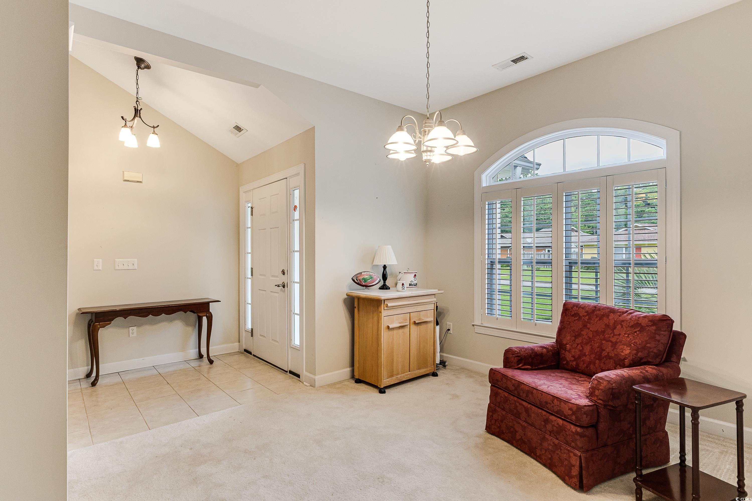 101 Cedar Tree Lane Southwest Calabash, NC 28467 - Photo 13 of 40 Sitting room with a chandelier, light colored carpet, and vaulted ceiling
