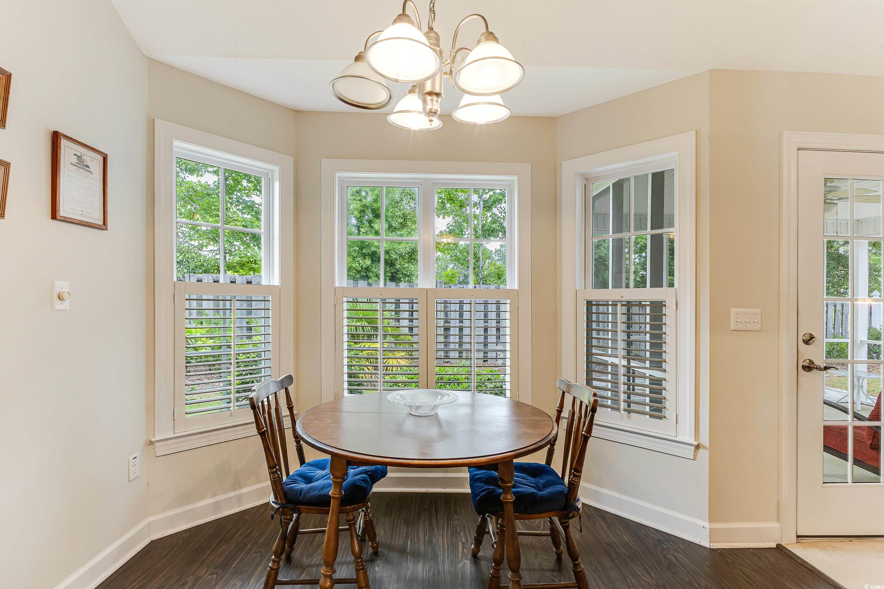 101 Cedar Tree Lane Southwest Calabash, NC 28467 - Photo 15 of 40 Dining area with a chandelier, healthy amount of natural light, and dark wood-type flooring