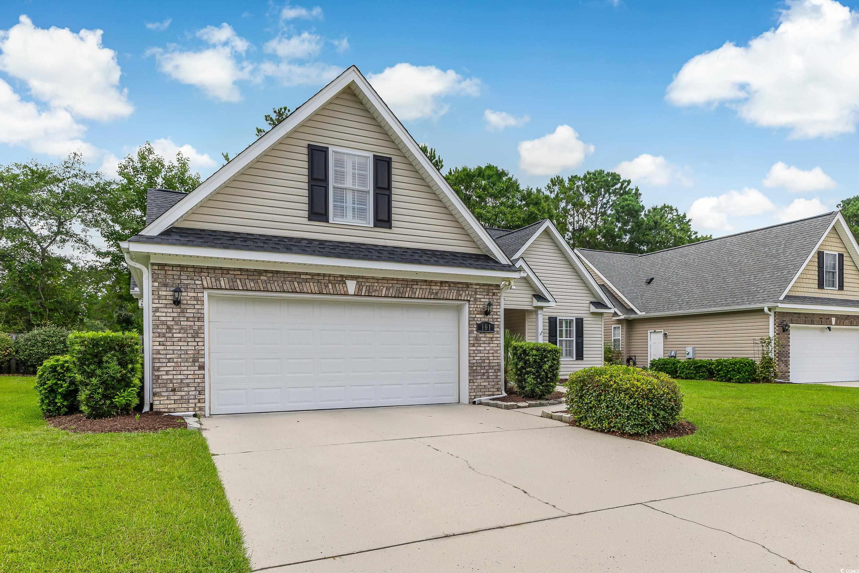 101 Cedar Tree Lane Southwest Calabash, NC 28467 - Photo 2 of 40 Traditional home featuring brick siding, concrete driveway, a front yard, and roof with shingles